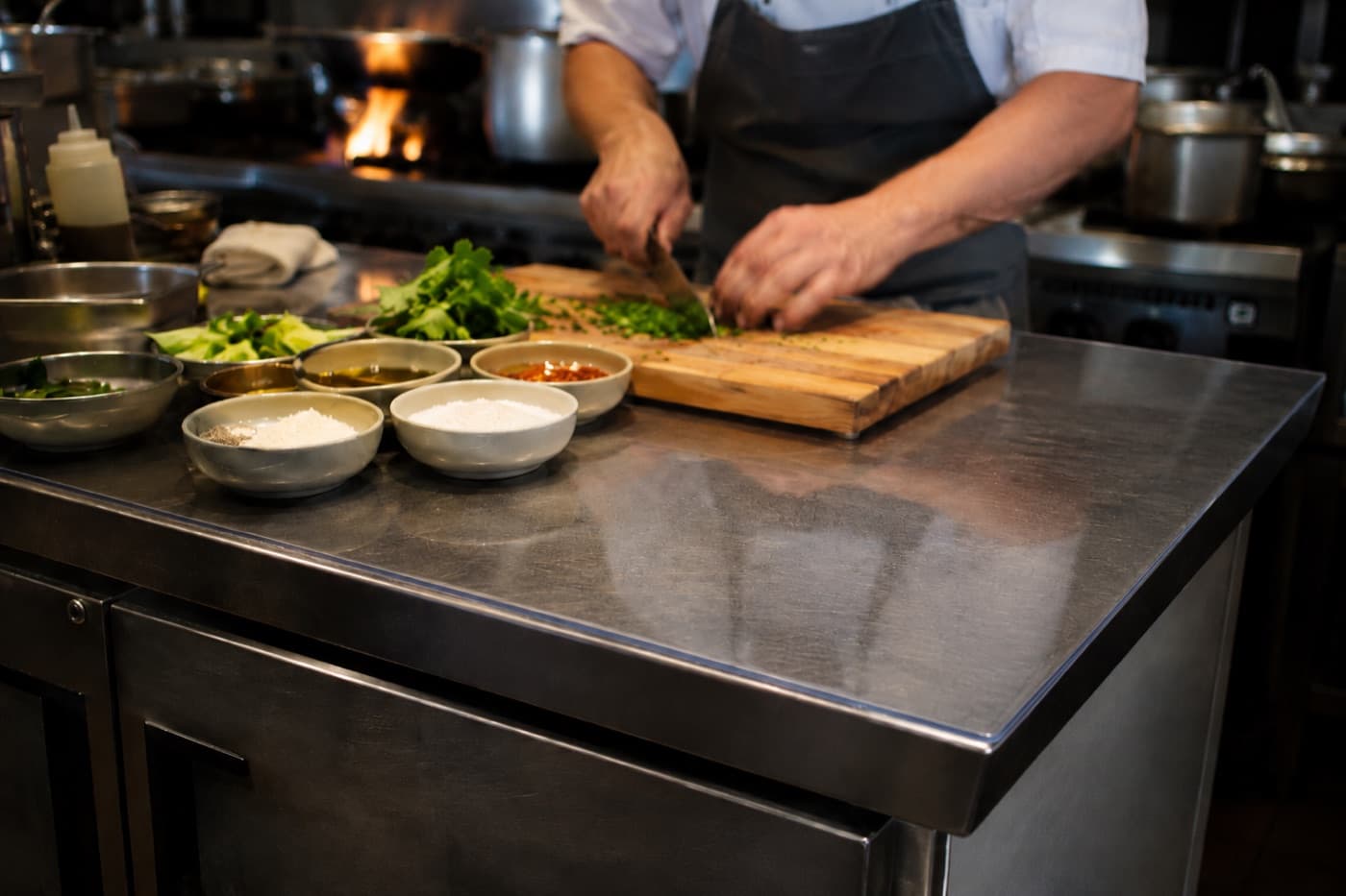 Arbeitsflächen in der Küche eines Restaurants, durch weiches Glas vor Wasserrändern geschützt